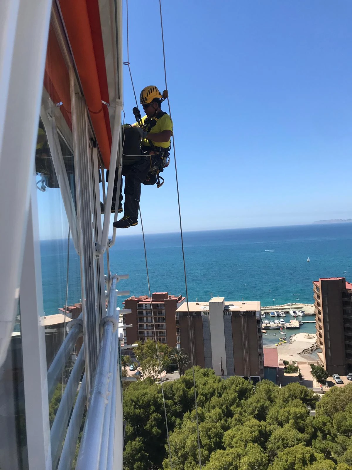 operario trabajos en altura fondo playa cristalera